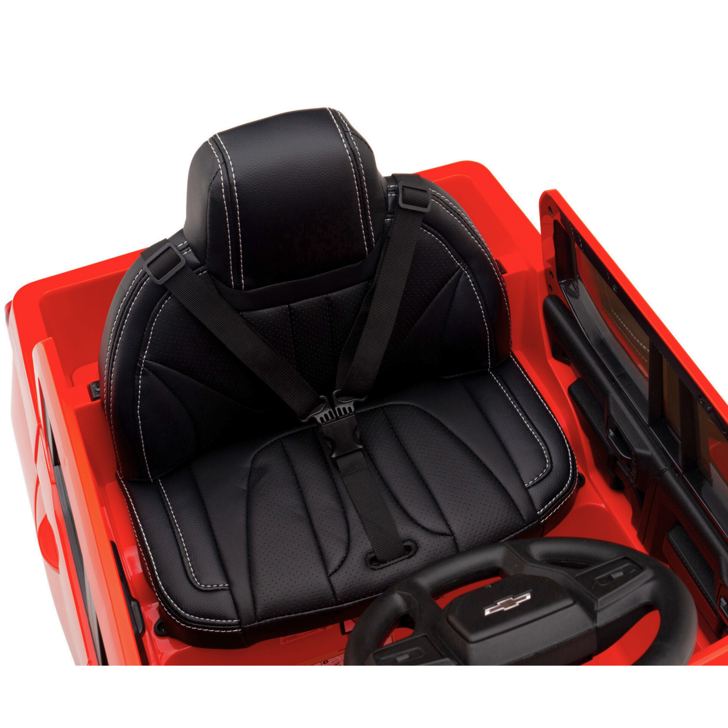 A top-down view of the Red 12V Chevrolet Silverado Kids Licensed 1 Seater Ride On Truck interior reveals a black leather seat with white stitching, a safety harness, and a partially visible dashboard featuring a small Chevrolet-logo steering wheel.
