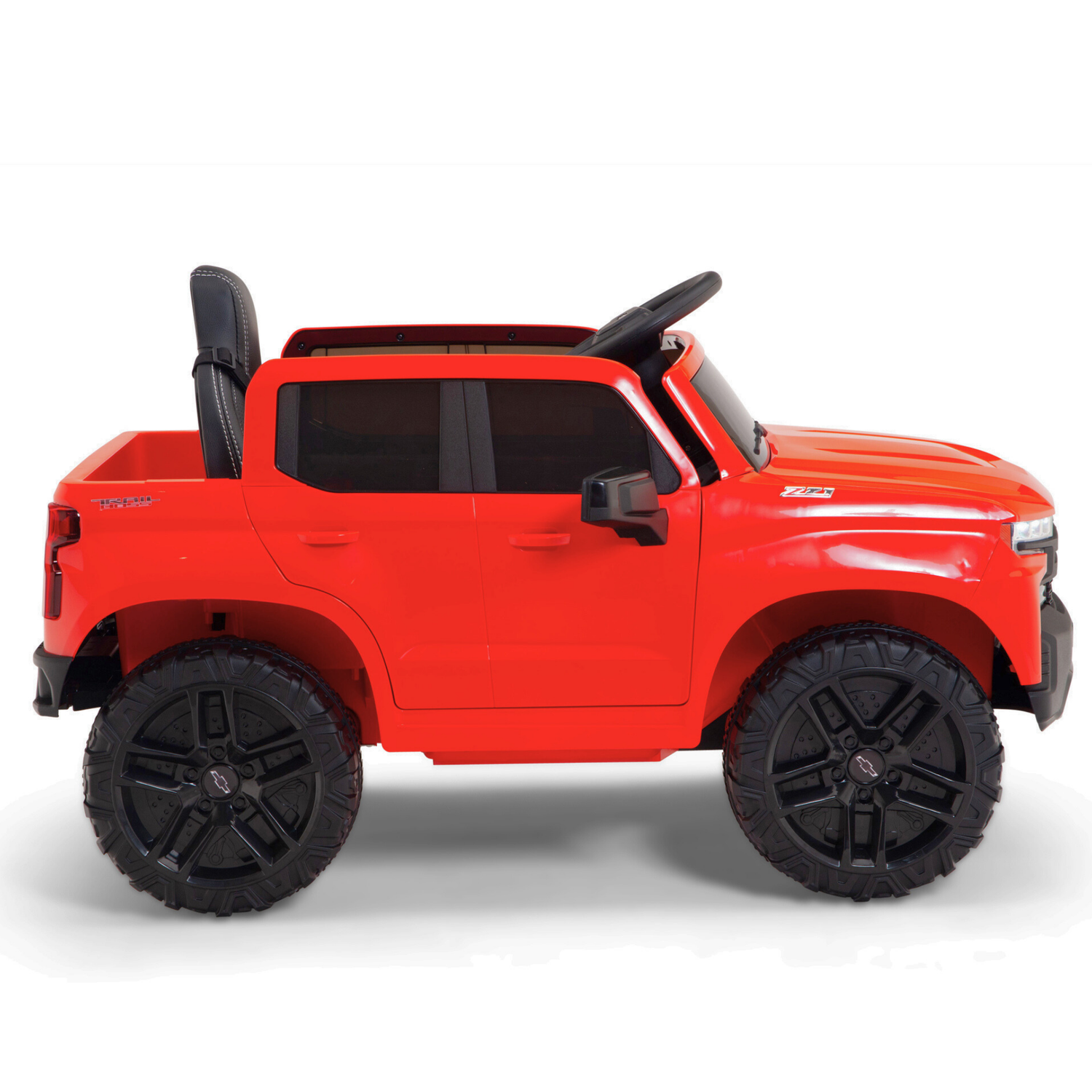 The Red 12V Chevrolet Silverado Kids Licensed Ride-On Truck boasts oversized black wheels and a sleek black seat, echoing the ruggedness of an off-road vehicle in profile view.