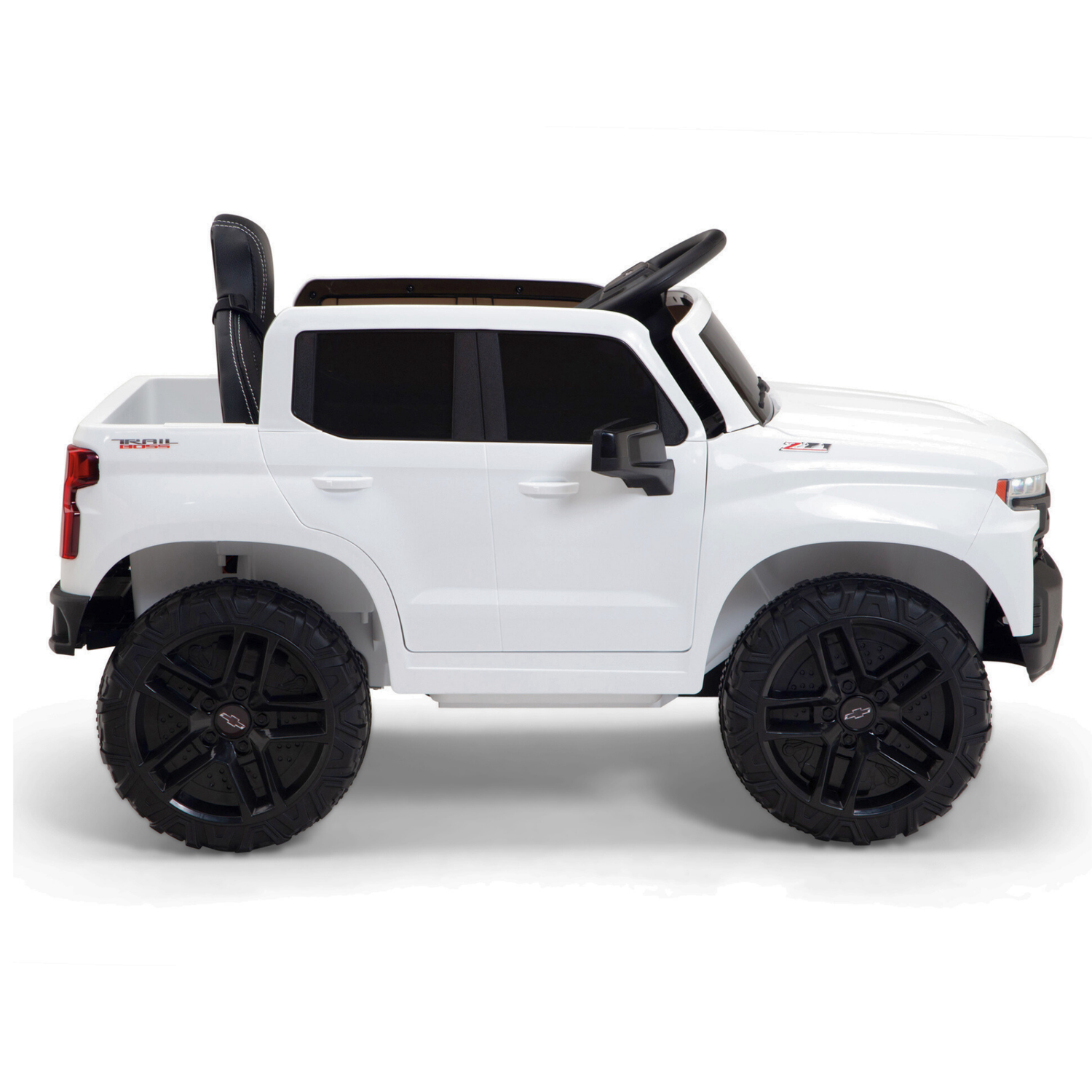 The White 12V Chevrolet Silverado Kids Licensed 1 Seater Ride On Truck features black wheels, high clearance, side mirrors, a black seat, music, and remote control—perfect for adventurous children.