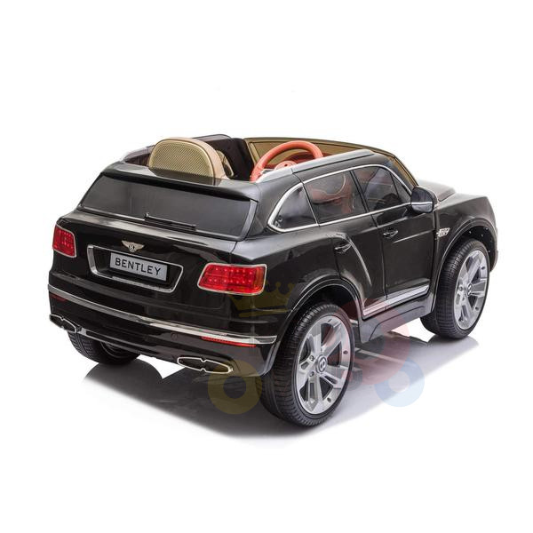 The Black Licensed Bentley Bentayga Complete Edition 12V Kids Ride On Car features detailed bodywork, chrome-like wheels, and a tan and red interior resembling leather seats, all set against a white backdrop. Its ideal for kids with its included parental remote control.