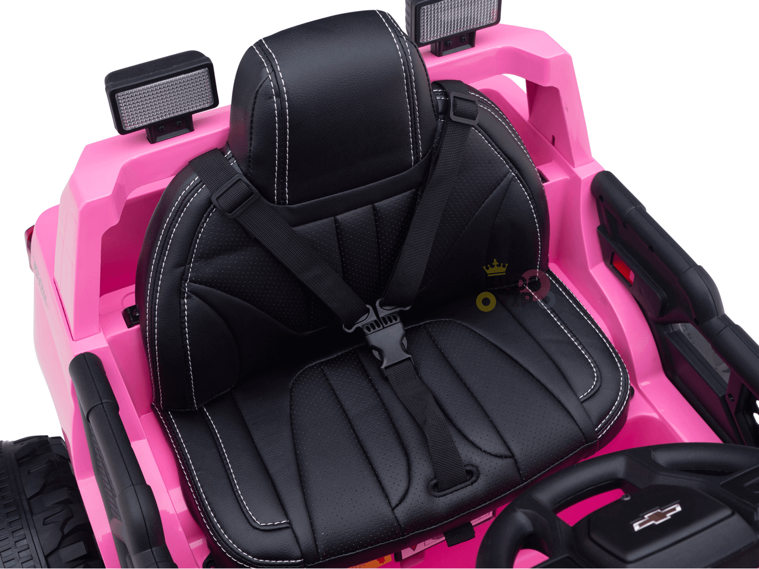 The Pink 24V Chevrolet Silverado Kids Licensed 1 Seater Ride On Lifted Truck features a charming interior with a black seat, white stitching, seatbelt, small steering wheel, and top light fixtures. Its streamlined dashboard ensures ease of use for young drivers.
