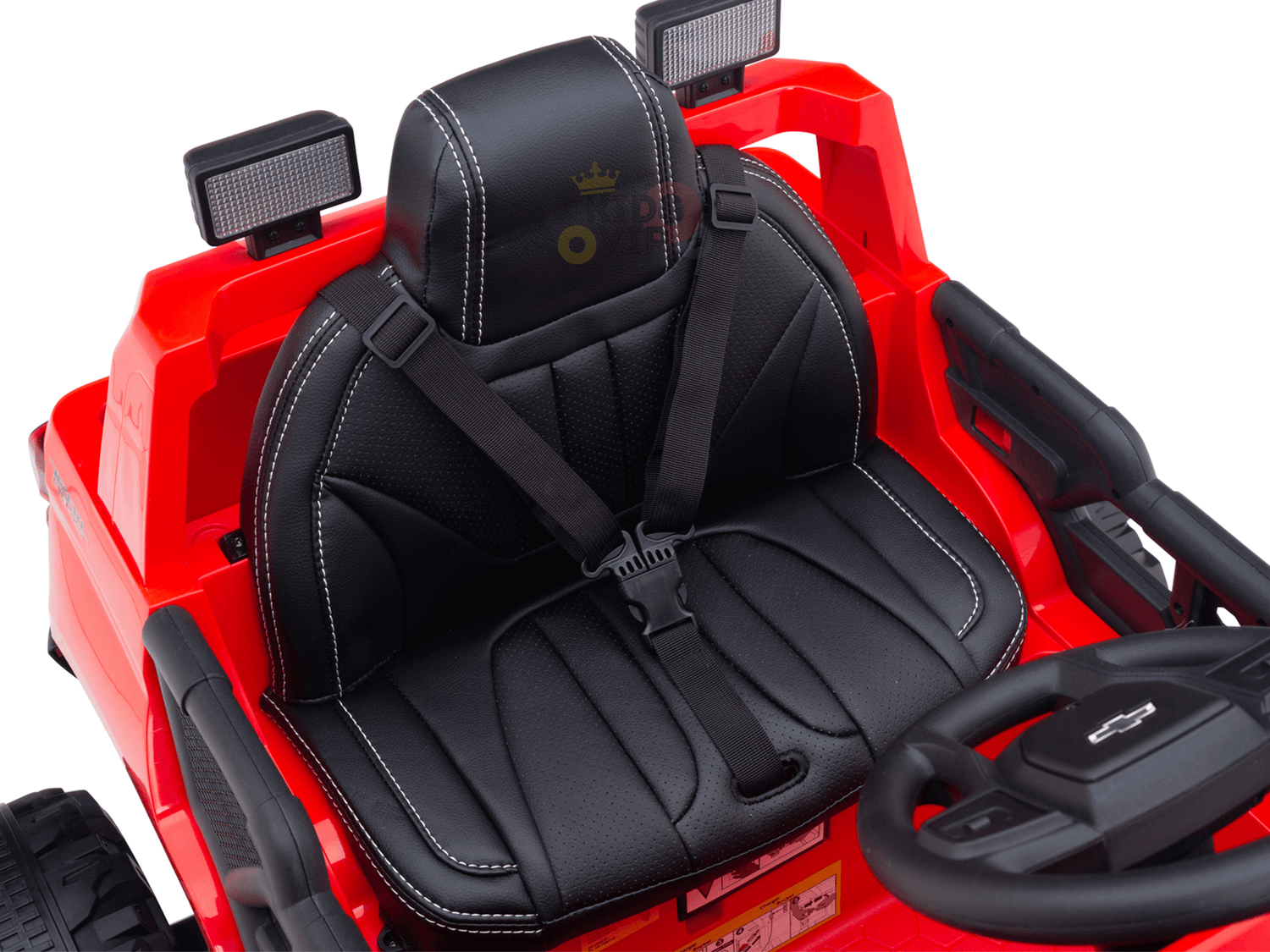 Close-up of a red 24V Chevrolet Silverado Kids Licensed 1 Seater Ride On Lifted Truck’s seat featuring black cushioning and white stitching. The seatbelt-equipped seat faces a black steering wheel, with two headlights on top—ideal for adventures on oversized wheels.