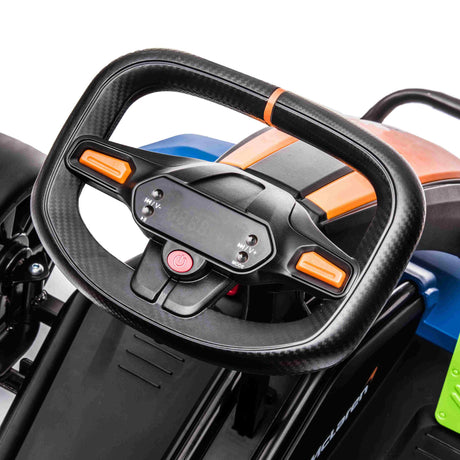 Close-up of the McLaren Orange 24V Super Drifting Go-Karts black and orange themed steering wheel, featuring an electronic display and central red power button for thrilling kid adventures. The panel includes blue and green accents.