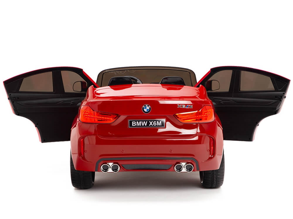 The Red 12V Licensed XXL BMW X6 Ride On Car features both doors that open, showcasing its realistic design with taillights, exhaust pipes, and a rear plate labeled BMW X6M.