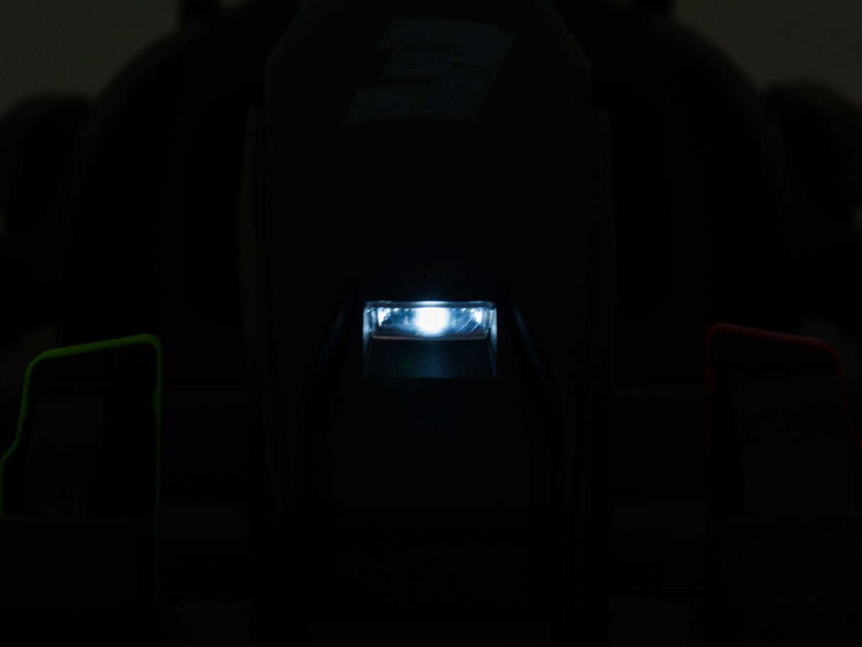 A dark image shows a brightly lit, small rectangular light at the center of a black, indistinct object. Faint green and red hints glimmer on either side, reflecting the excitement of a Big Kids Powerful 24V Speedster Drifting Go-Kart.