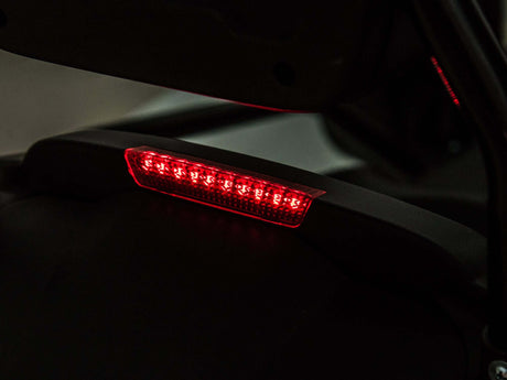 A close-up of an LED taillight in low light shows a sleek black casing with a modern design, reminiscent of the dynamic curves on the Big Kids Powerful 24V Speedster Drifting Go-Kart.