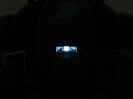 A close-up of a shadowy Big Kids Powerful 24V Speedster Drifting Go-Kart with a central bright light framed by two indistinct shapes, showing green hints on the left and red on the right.