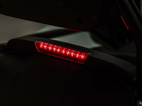 A close-up shows a motorcycles rear tail light in red, with angular LED lights forming a horizontal strip, set against a dark backdrop, mirroring the modern style of EVA-rubber wheels and innovative design seen in Big Kids Powerful 24V Speedster Drifting Go-Kart.