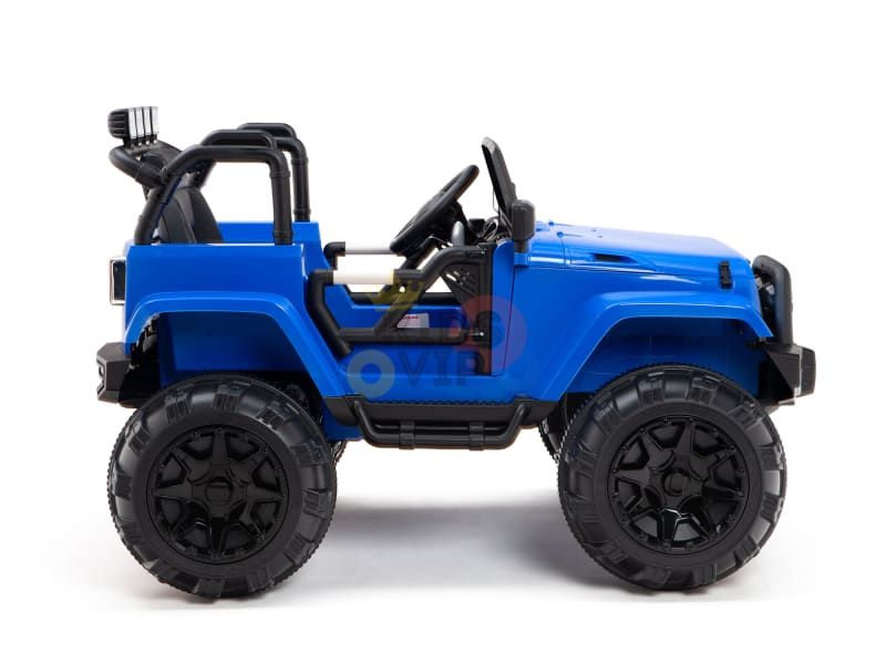 A blue 12V Sport Edition Trailcat Big Wheels kids ride-on truck with oversized black wheels and a visible steering wheel is shown in profile against a plain white background, featuring an open-top design for adventurous play.