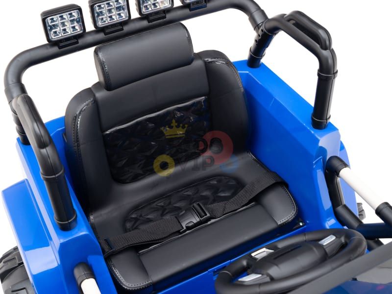 A close-up of the Blue 12V Sport Edition Trailcat Big Wheels kids ride-on truck interior showcases a blue and black design with a cushioned seat, safety harness, steering wheel, and six overhead spotlights. The plastic-textured dashboard ensures a fun and safe adventure for kids.