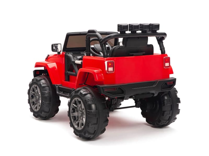 The Red 12V Sport Edition Trailcat Big Wheels Kids Ride on Truck with RC is a small red toy jeep featuring oversized black wheels, an open top, and a roll bar. Positioned slightly to the left, it displays its rugged rear and side against a plain white background.