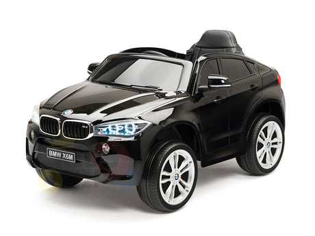 The Limited Licensed BMW X6M 12v Kids Ride On Car features a sleek black design, large wheels, realistic grill, illuminating headlights, and child-friendly seat. With high-performance elements and a parental remote control, this miniature marvel enhances playtime significantly.