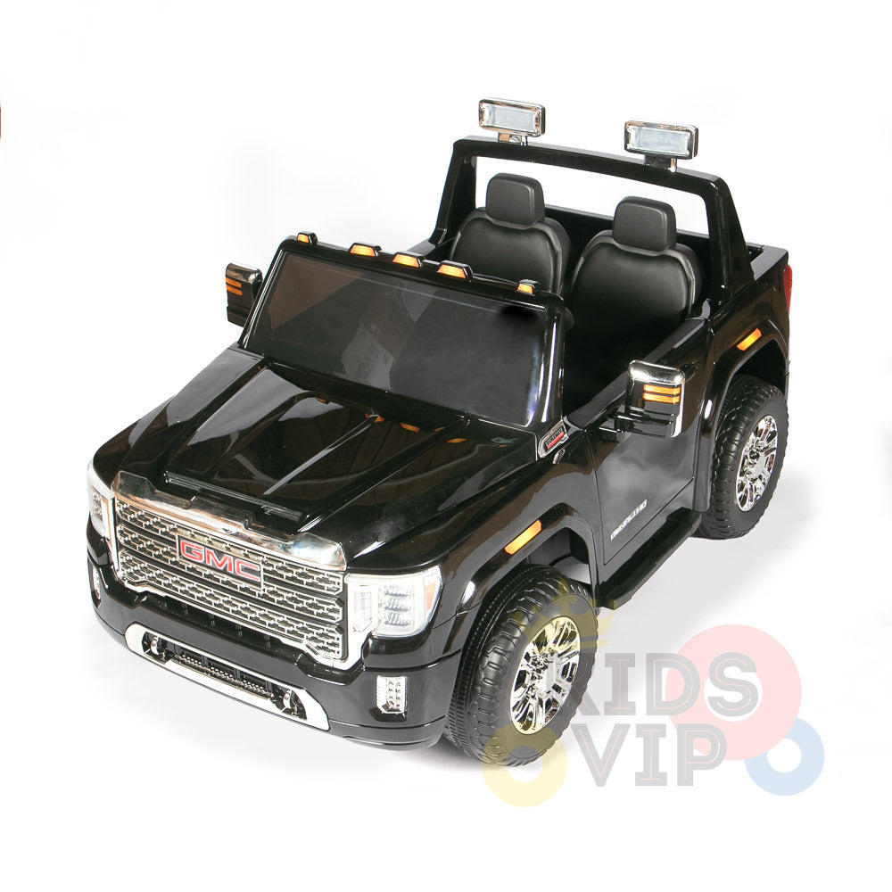 The Black 2x12V Licensed 4WD GMC Sierra Kids Ride On Car with RC features a detailed front grille, two seats, side mirrors, replica headlights, an open top, sturdy wheels, and a parental remote control for safety. Its presented on a plain white background.