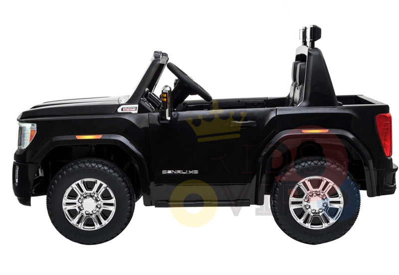 The Black 2x12V Licensed 4WD GMC Sierra Kids Ride On Car with RC mimics a truck with large wheels, realistic details, and an open top. It features chrome accents, a side mirror in the side view, and includes a parental remote control for safety and fun.