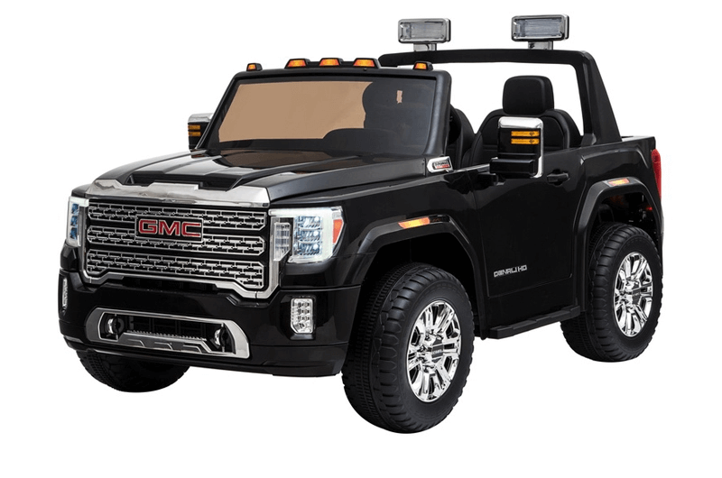 This sleek black ride-on car, Enhance Your GMC Sierra Experience with a 12v/2 Seater Windshield, resembles a GMC truck with chrome accents, large wheels, and two seats. It features a detailed front grille, clear headlights, roof light bars, and the Denali logo on the side. Limited colors in stock—final sale!.