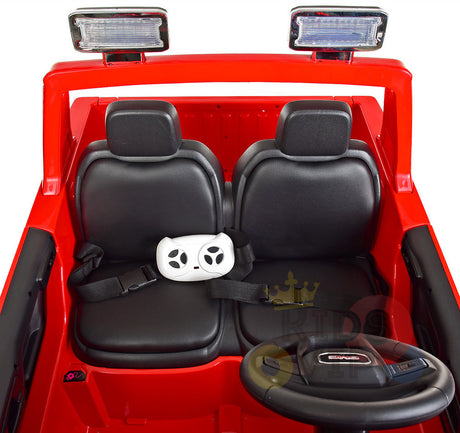 The Black 2x12V Licensed 4WD GMC Sierra Kids Ride On Car features two black seats, a small steering wheel, and a gaming-style remote secured on the left seat with a seatbelt. Above the windshield, it has two rectangular lights mounted on the frame.