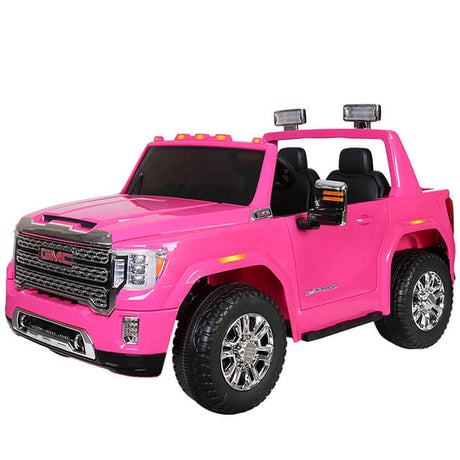 This pink toy GMC Sierra has large wheels, side mirrors, a sleek black interior, chrome grille, and shiny hubcaps. Its open doors ease entry for kids. Powered by a 2x12v complete battery package for 12v/2 seater adventures.