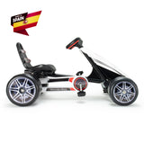 The INJUSA Officially Licensed Mercedes Pedal Go Kart for Kids is a stylish outdoor toy with a black and white design adorned with red accents. It features large wheels, an adjustable seat, the iconic Mercedes-Benz logo, and a Made in Spain badge.