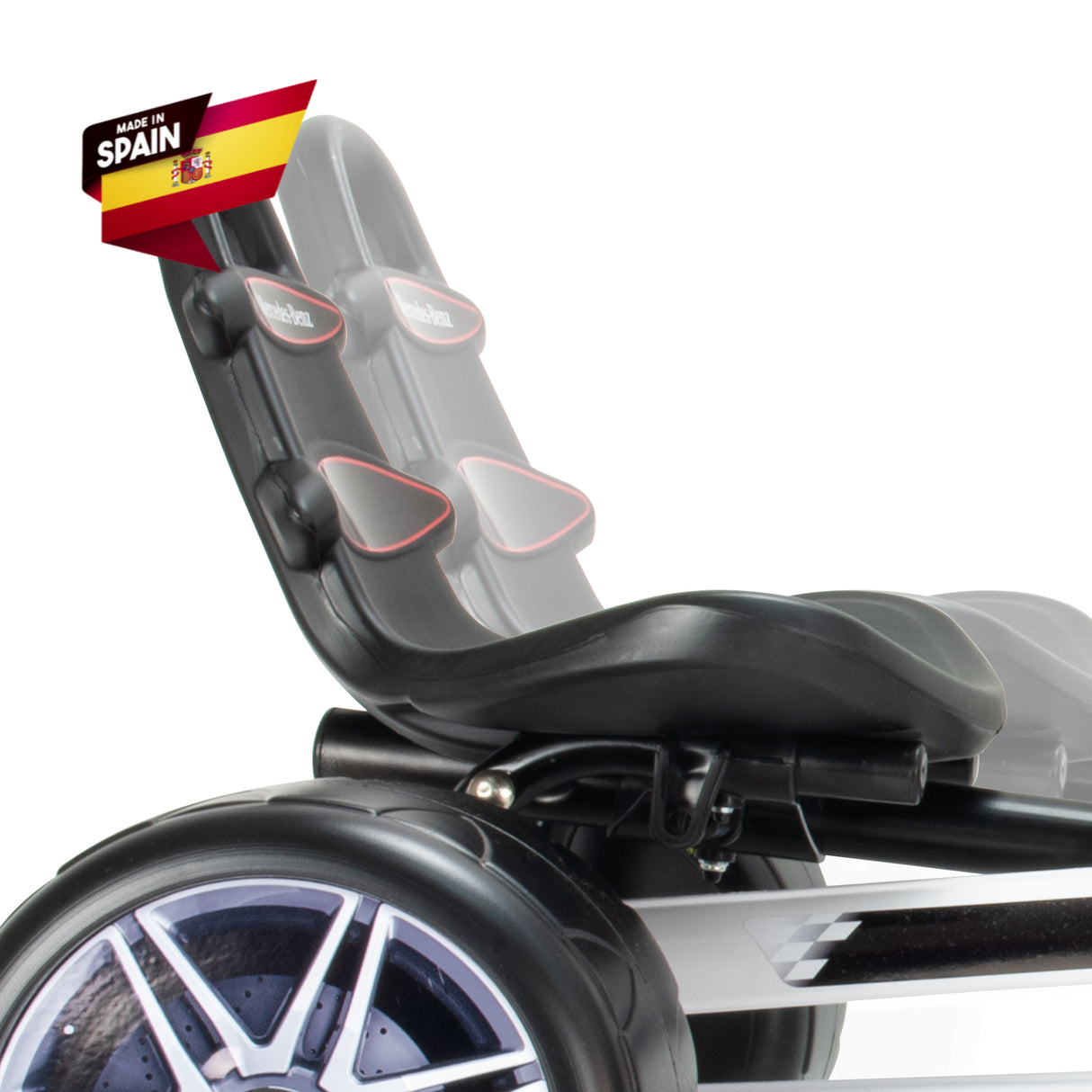 Close-up of a black seat with red accents and harness straps on the INJUSA Officially Licensed Mercedes Pedal Go Kart for Kids. A Made in Spain flag emblem appears top left. The image focuses on the seat and wheel, set against a white background, showcasing this exciting kids outdoor toy.