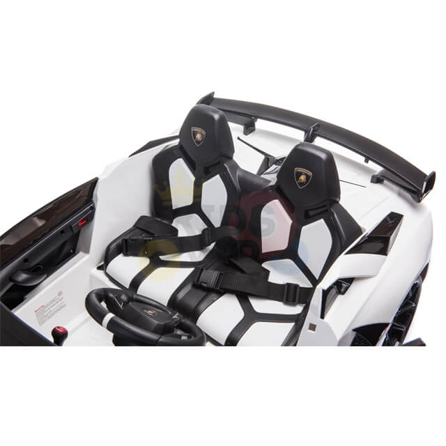 The Upgrade Your Ride with the White 24v Lamborghini SVJ Drifting Kids Ride on Car features a sleek design with two-tone seats, safety harnesses, a steering wheel, detailed dashboard with black accents, and drifting wheels for sporty fun. Powered by a 24V battery for action-packed excitement.
