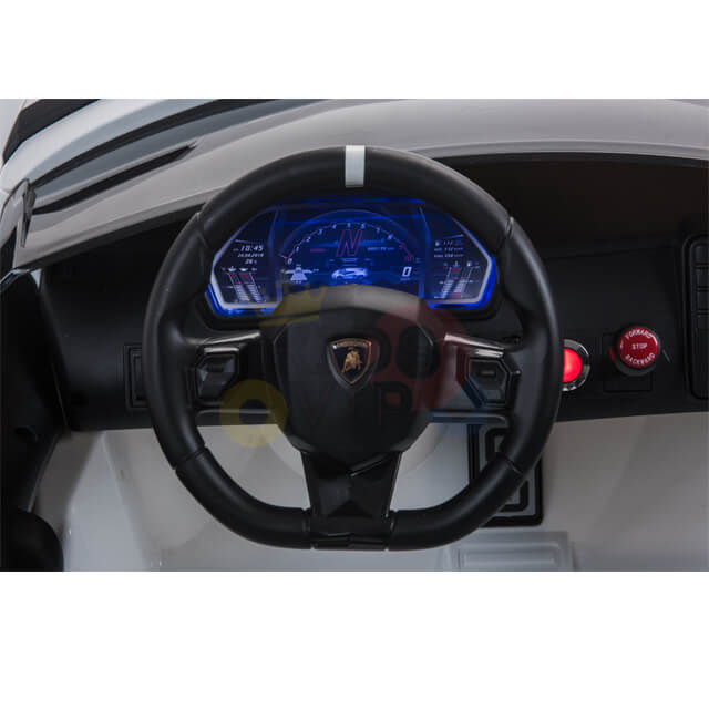 Close-up of a car dashboard from the White 24v Lamborghini SVJ Drifting Kids Ride on Car, featuring a black steering wheel with logo, blue-lit digital display showing info with drifting wheels tech, and to the right, a red button and additional controls.
