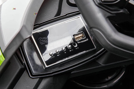 Close-up of the Green 12V Official Lamborghini Vision GT Kids Ride-on Car dashboard, showcasing a sleek black stereo system with buttons for MODE, VOL⁺, VOL⁻, and AUX, plus a USB port and digital display, inspired by the Lamborghini Vision GT.