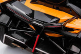 Close-up of the rear section of an Orange 12V Official Lamborghini Vision GT Kids Ride on Car, showcasing sleek, angular design similar to a Lamborghini Vision GT with red accents. Prominent branding near the top center highlights its striking style.