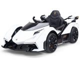 The White 12V Official Lamborghini Vision GT Kids Ride-on Car features a sleek design, black accents, and angular lines. With pedal controls and detailed wheels, it provides an authentic luxury sports car experience.