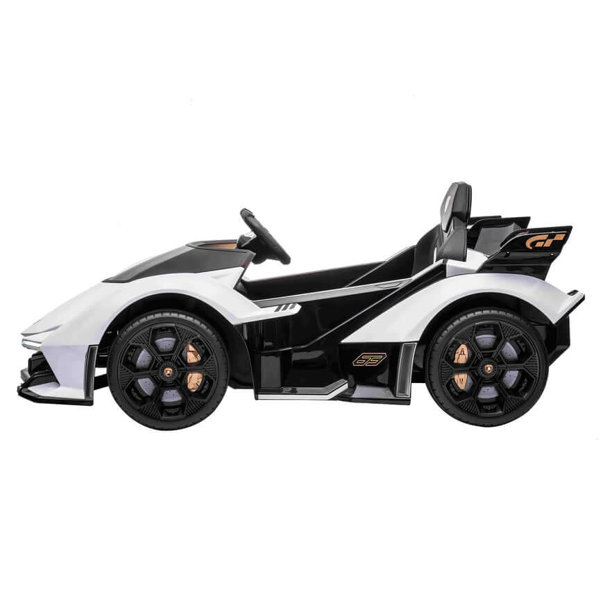Side view of the White 12V Official Lamborghini Vision GT Kids Ride-On Car, featuring black and gold accents. Its sporty design includes curved lines, a steering wheel, and large black wheels with gold details, powered by a robust battery for ultimate playtime fun.