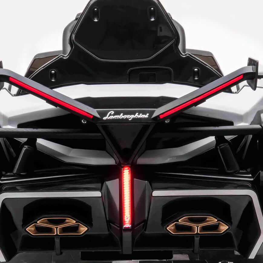 The White 12V Official Lamborghini Vision GT Kids Ride-On car features a design inspired by the real Lamborghini, showcasing sleek black and white body, distinctive rear lights, bold angular lines, and the iconic logo—a dream car for thrilling kids adventures.