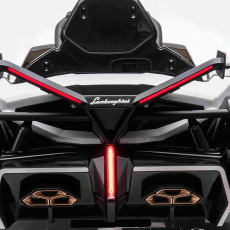 The White 12V Official Lamborghini Vision GT Kids Ride-On car features a design inspired by the real Lamborghini, showcasing sleek black and white body, distinctive rear lights, bold angular lines, and the iconic logo—a dream car for thrilling kids adventures.