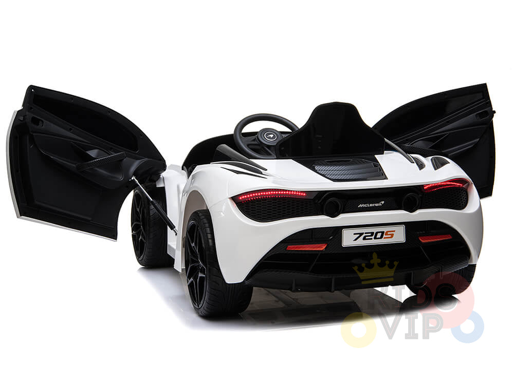 The White 12V McLaren 720S Kids Licensed Ride On Car features a black interior with a sporty steering wheel and upgraded elements. Both doors are open, revealing the sleek design with visible rear lights and 720S on the license plate, positioned diagonally for maximum effect.