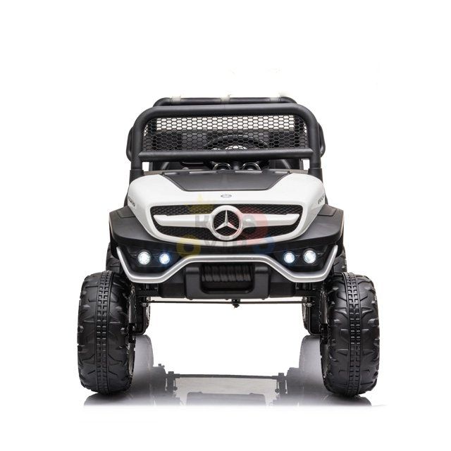 Meet the White 12V/4X4 Official Mercedes Unimog Junior Ride On UTV with rugged tires, a bold grille, and bright headlights. This black and white beauty is perfect for adventures, embodying the spirit of a remote-controlled off-roader.