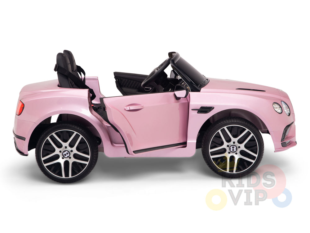 The Pink 12V Bentley GTC Kids Licensed Ride On Car features rubber wheels, opening doors, and two sleek black seats. KIDS VIP is printed on it, providing a safe driving experience for kids with its parental remote control.