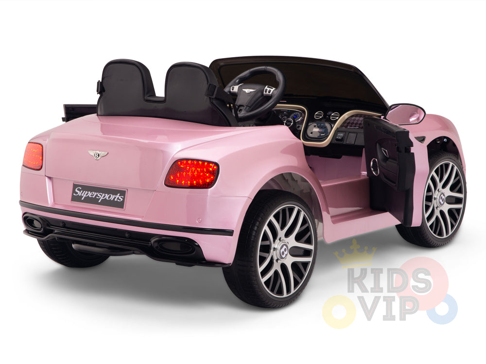 The Pink 12V Bentley GTC Kids Licensed Ride-On Car with Rubber Wheels is shown from the rear and side, featuring black seats, an open door, detailed dashboard, shiny wheels, and a partially visible Kids VIP logo. It includes a parental remote control for added safety.