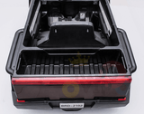 The open bed of the Futuristic 12V Police Truck Ride On, featuring a red light and license plate BRD-2102, offers a sleek design reminiscent of futuristic series, with black bodywork and visible ridges enhancing its utilitarian elegance like emergency vehicles.