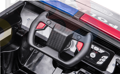 A close-up of the toy police trucks dashboard and steering wheel from the Futuristic 12V Police Truck Ride On, featuring red buttons, dials, and controls. Police lights on the roof highlight its role among emergency vehicles for kids and toddlers.