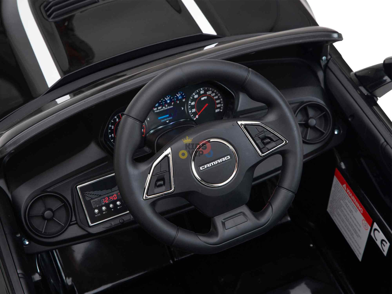 Close-up of the dashboard in a Black Official Sport 12V Chevrolet Camaro Kids and Toddlers Ride on Car, showcasing a Camaro branded steering wheel. The sleek interior features black surfaces, chrome accents, and includes EVA rubber wheels with an ECO leather seat for added comfort.