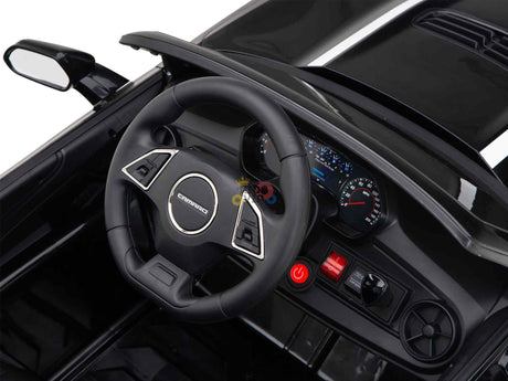 Close-up of the Black Official Sport 12V Chevrolet Camaro Kids and Toddlers Ride on Cars interior with a Camaro steering wheel, speedometer and gauge decals on the dashboard, control-like buttons, shiny surfaces, Eva rubber wheels, and a comfortable ECO leather seat.