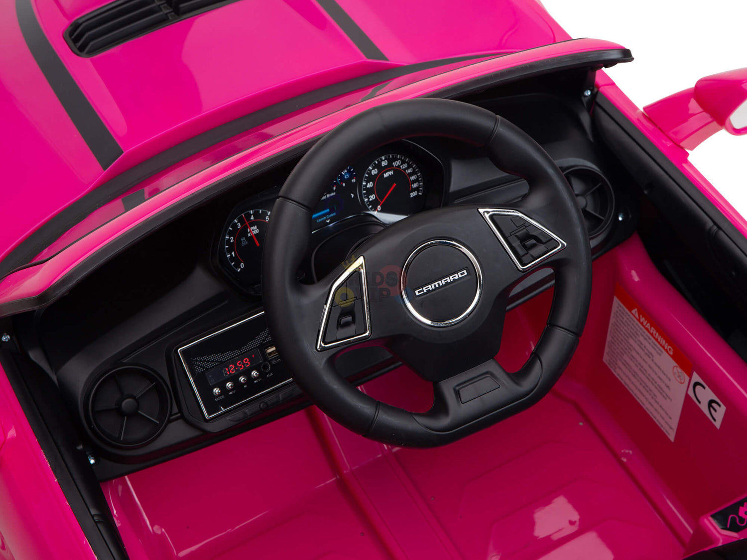 Close-up of the vibrant pink Chevrolet Camaro ride-on car dashboard and steering wheel, featuring a speedometer and silver-accented wheel with logo, perfectly capturing the fun and excitement for kids.