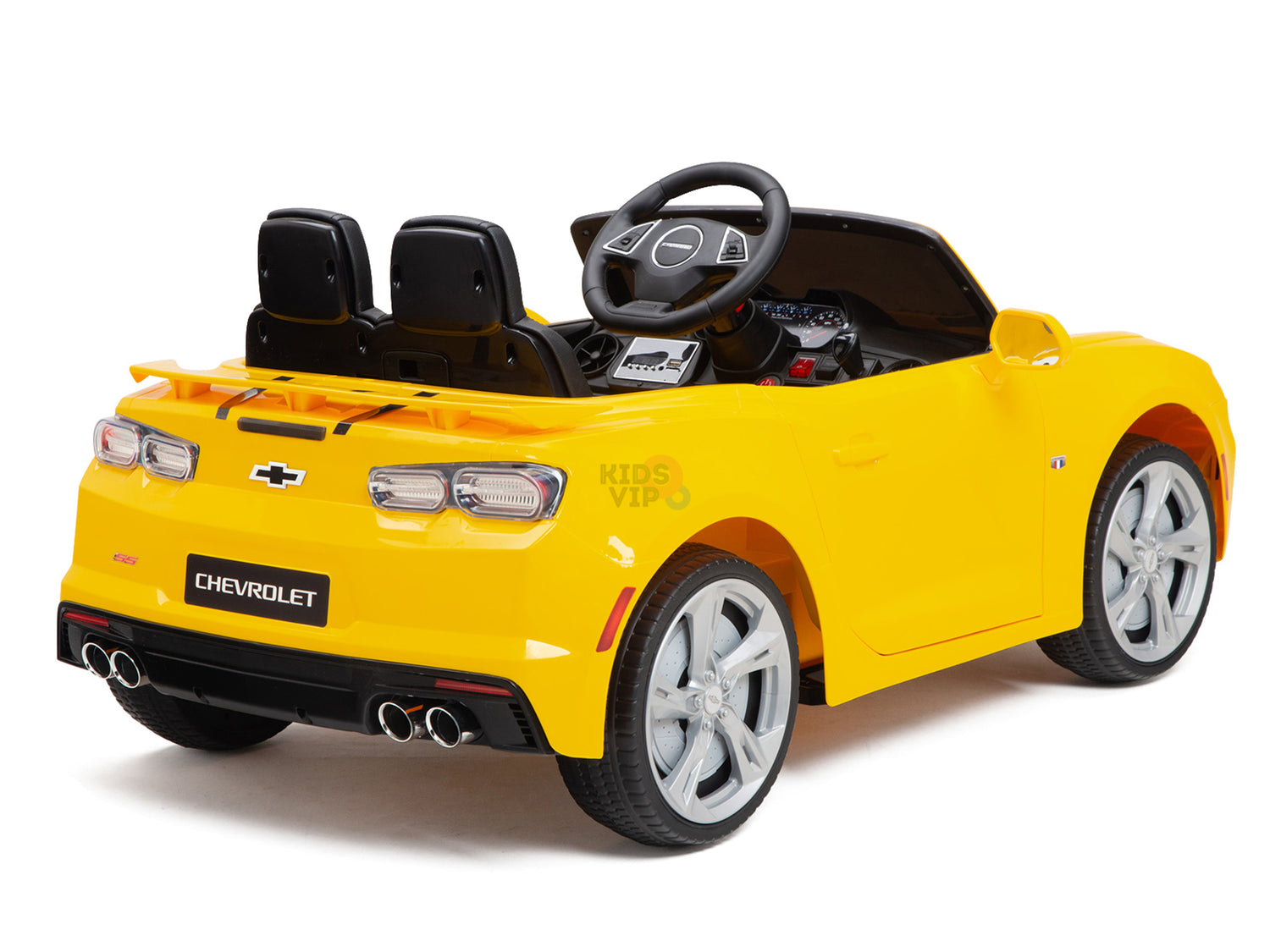 A yellow 12V Official Sport Chevrolet Camaro ride-on car for kids and toddlers, featuring a black-seat convertible design with silver wheels. The rear right view showcases its realistic steering wheel, dashboard, visible Chevrolet logo, and dual exhaust pipes.