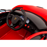 The interior of the Red 12V Lamborghini SVJ Sport Kids Licensed Ride On Car features a steering wheel with a yellow emblem, lit screens, control buttons on the dashboard, and matching red seats for a sleek look.