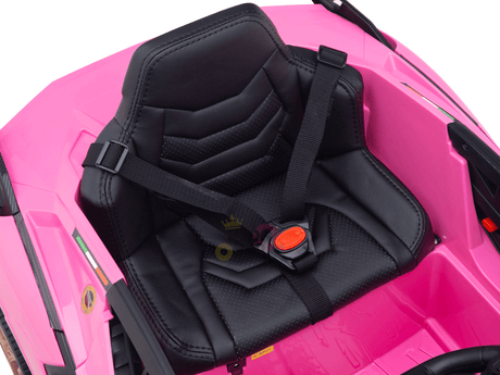 Close-up of a black and pink toy car seat with harnesses, designed for the 12V Lamborghini Sian Kids Ride On Car. It features a textured design, an adjustable strap with red buckle, and is ready for fun with its bright pink surroundings and 12V power source.