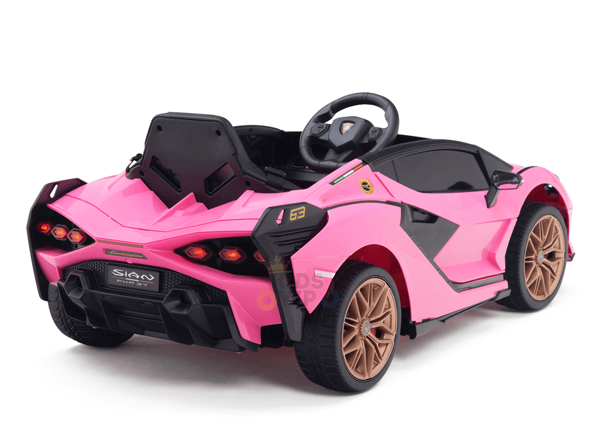 The Official 12V Sport Edition Lamborghini Sian Kids and Toddlers Ride On Car is shown from the back in pink with black accents and golden wheels. It has a detailed interior, steering wheel, rear lights, branding on the body, and runs on a powerful 12V battery.